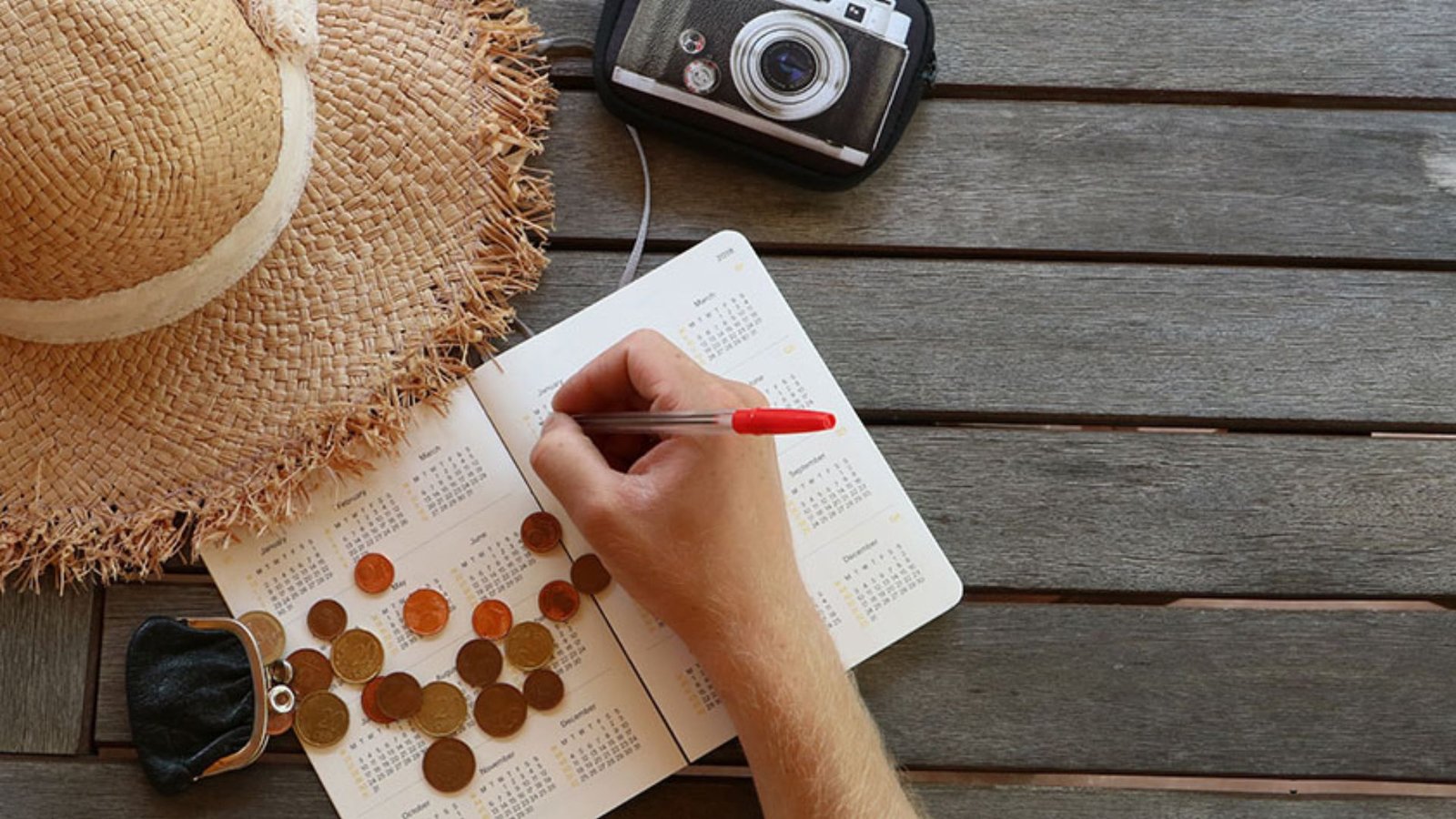 A person writing and planning a Budget-Friendly Vacation